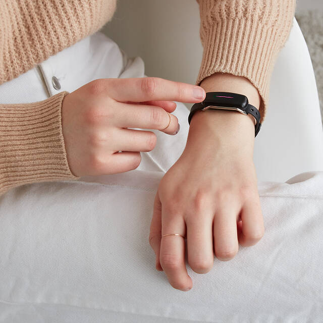 female tapping long distance touch bracelet to send message to friend