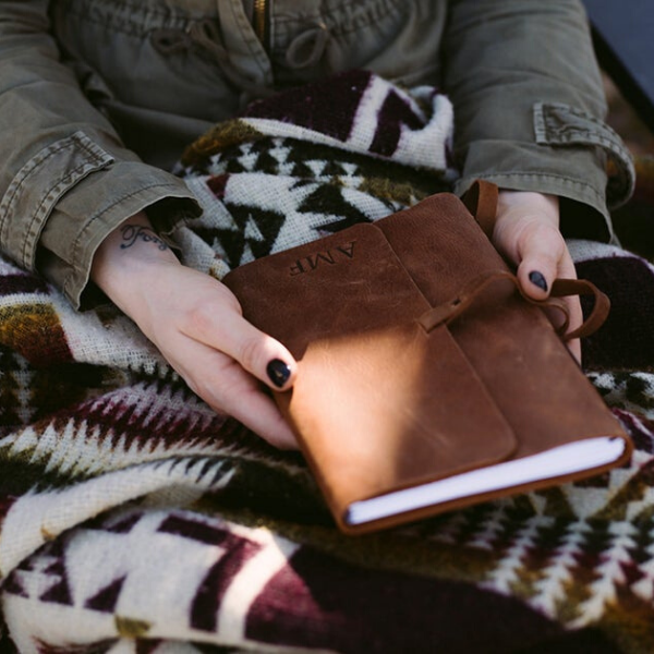 Woman holding a personalized brown leather journal