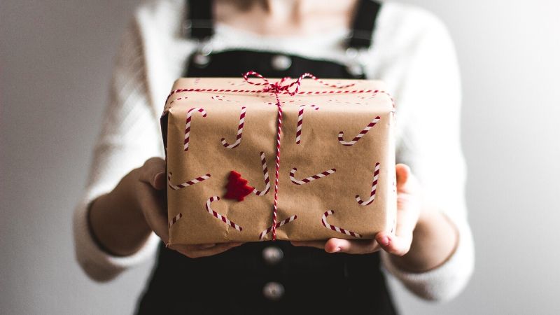 woman holding a christmas themed package