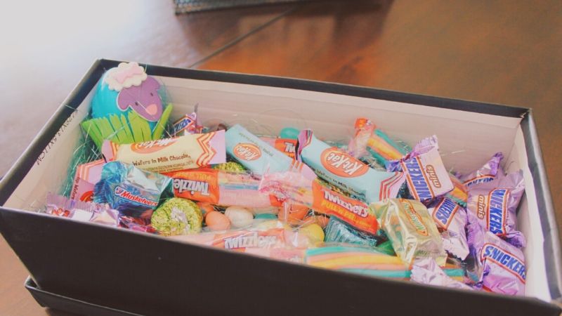 different candy and chocolate in a junk food care package box