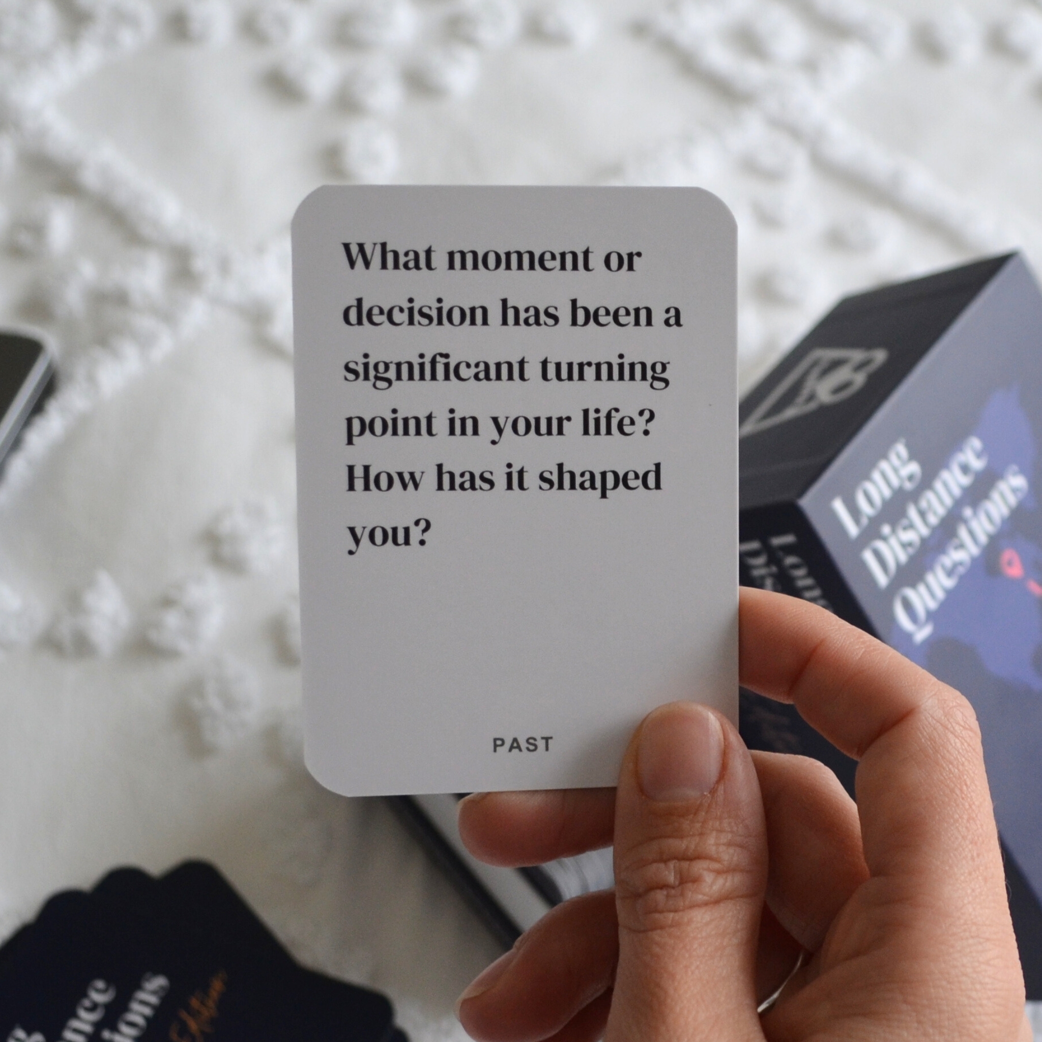 A person holding a card with reflective questions about significant life turning points.